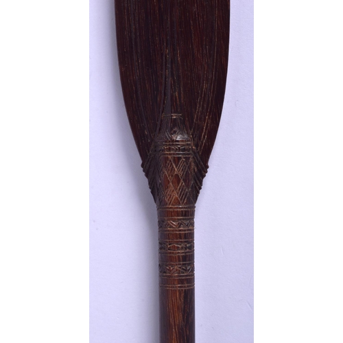 321 - A TRIBAL AUSTRALIAN CARVED WOOD BOOMERANG together with a palm wood paddle. Largest 62 cm long. (2)