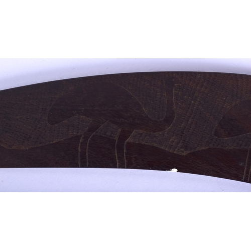 321 - A TRIBAL AUSTRALIAN CARVED WOOD BOOMERANG together with a palm wood paddle. Largest 62 cm long. (2)