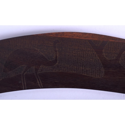 321 - A TRIBAL AUSTRALIAN CARVED WOOD BOOMERANG together with a palm wood paddle. Largest 62 cm long. (2)