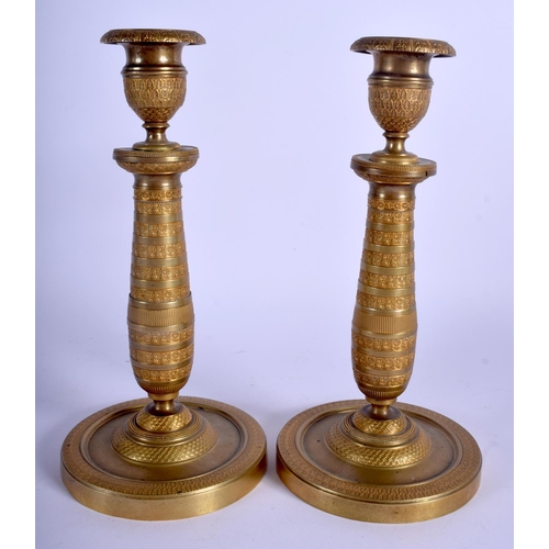 745 - A PAIR OF 19TH CENTURY FRENCH EMPIRE GILT METAL CANDLESTICKS decorated with a flower banding. 23 cm ... 