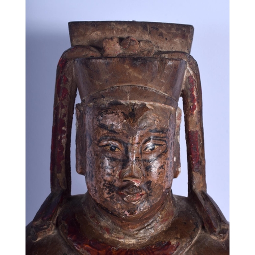 1310 - A LARGE EARLY CHINESE POLYCHROMED WOOD FIGURE OF A SEATED SCHOLAR Late Ming/Qing, modelled holding a... 