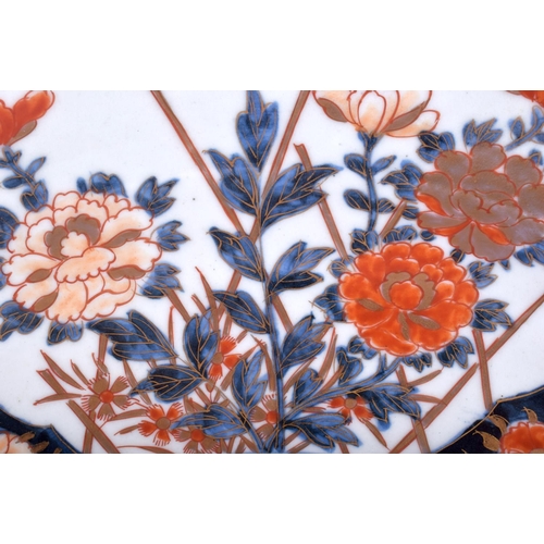 1323 - A LARGE 18TH CENTURY JAPANESE EDO PERIOD IMARI CHARGER painted with urns and floral sprays. 45 cm di... 