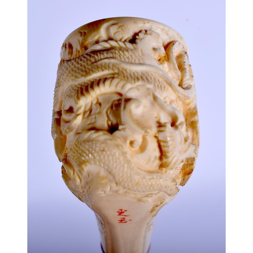 1639 - AN EARLY 20TH CHINESE CANTON IVORY PIPE Qing, modelled with a dragon terminal. 15 cm wide.