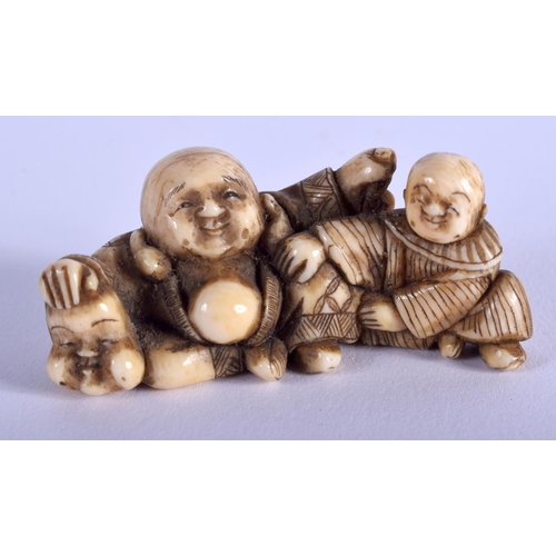 1067 - A 19TH CENTURY JAPANESE MEIJI PERIOD CARVED IVORY NETSUKE modelled as a buddha and boy. 5 cm x 2.5 c... 