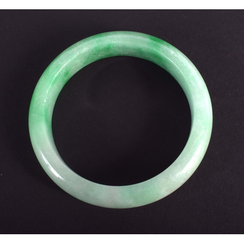 1236 - A CHINESE CARVED JADEITE BANGLE 20th Century. 7.25 cm wide.