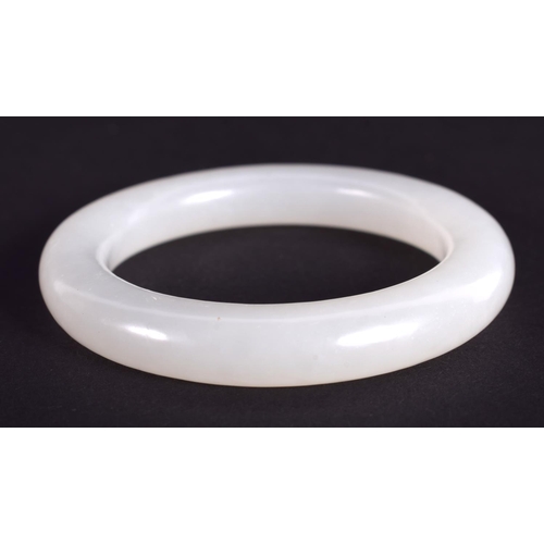 1265 - A CHINESE CARVED WHITE JADE CHILDS BANGLE 20th Century. 5.5 cm diameter.