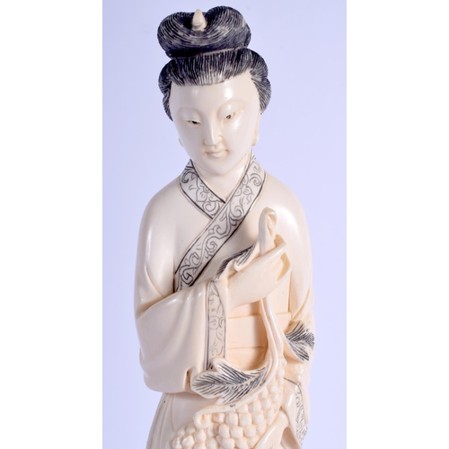 1374 - AN EARLY 20TH CENTURY CHINESE CARVED IVORY FIGURE OF A FEMALE modelled holding a fruiting hanging. I... 