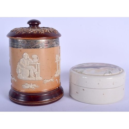 138 - AN ANTIQUE SILVER MOUNTED DOULTON LAMBETH TOBACCO JAR AND COVER together with a paste pot. (2)