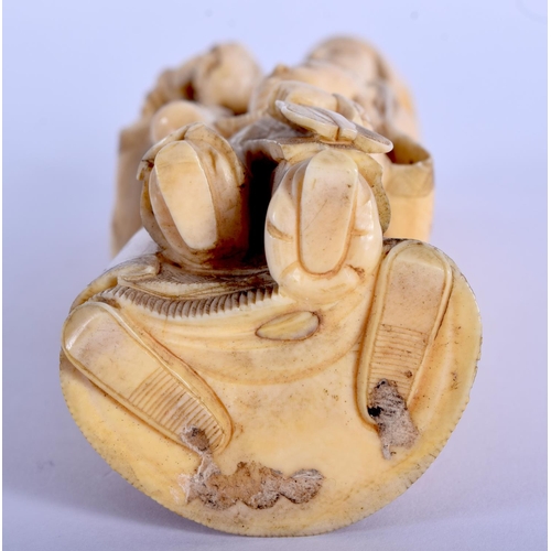 1392 - A 19TH CENTURY JAPANESE MEIJI PERIOD CARVED IVORY OKIMONO modelled as a male and child holding fruit... 