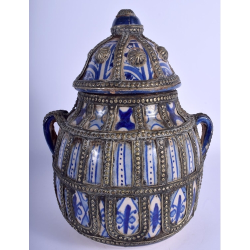 152 - A MIDDLE EASTERN FAIENCE JAR AND COVER with white metal overlay. 26 cm x 16 cm.