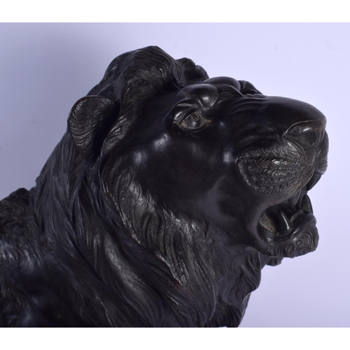 1601 - A 19TH CENTURY JAPANESE MEIJI PERIOD BRONZE OKIMONO modelled as a roaming lion upon a wooden plinth.... 