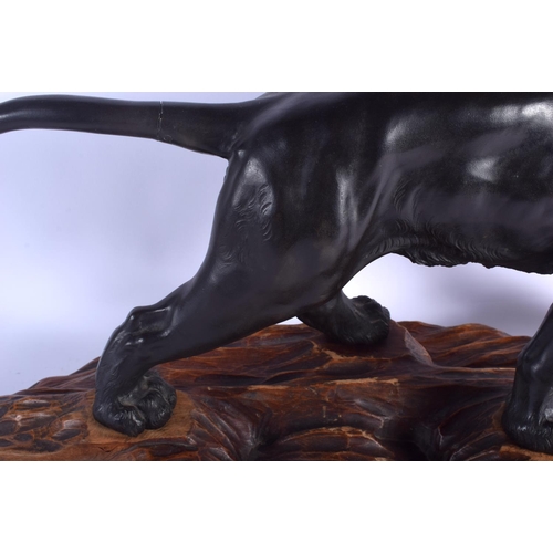 1601 - A 19TH CENTURY JAPANESE MEIJI PERIOD BRONZE OKIMONO modelled as a roaming lion upon a wooden plinth.... 