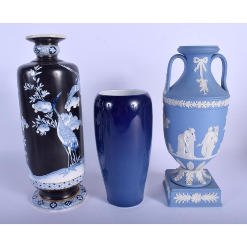 180 - A WEDGWOOD BLUE BASALT TWIN HANDLED VASE together with two other vases. Largest 24 cm high. (3)