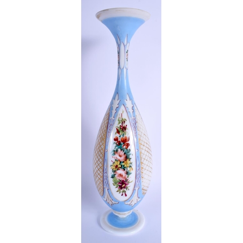 20 - AN ANTIQUE BOHEMIAN BLUE AND ENAMELLED OPALINE GLASS VASE painted with flowers. 36 cm high.