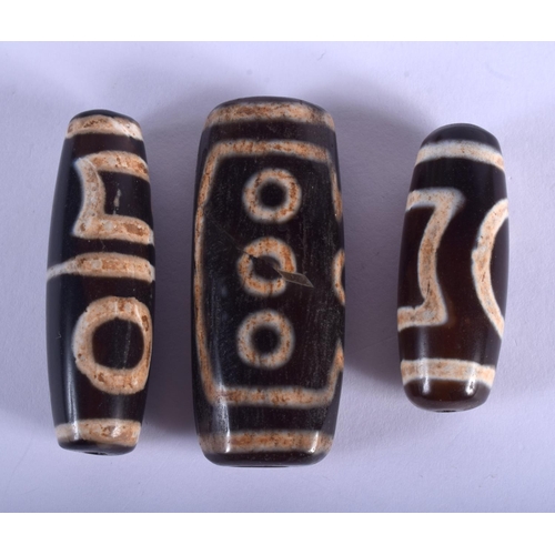 2142 - THREE CHINESE TIBETAN ZHU BEADS. Largest 5.5 cm long. (3)