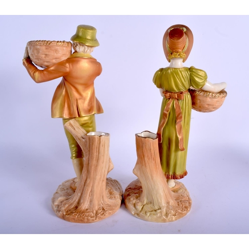 256 - Royal Worcester blush ivory and shot enamel pair of figures of a boy and girl carrying a basket afte... 