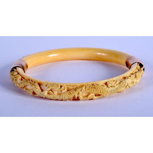 1068 - A 19TH CENTURY CHINESE CARVED IVORY DRAGON BANGLE Qing. 8.5 cm diameter.