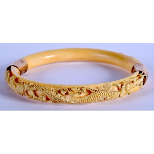 1068 - A 19TH CENTURY CHINESE CARVED IVORY DRAGON BANGLE Qing. 8.5 cm diameter.