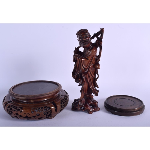 1087 - A 19TH CENTURY CHINESE CARVED HARDWOOD FIGURE OF AN IMMORTAL together with two stands. (3)