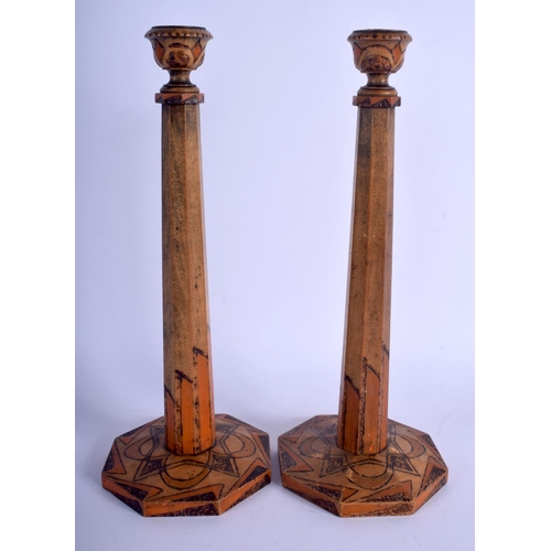 514 - A PAIR OF EUROPEAN ART DECO PAINTED WOODEN CANDLESTICKS of angular design. 31 cm high.