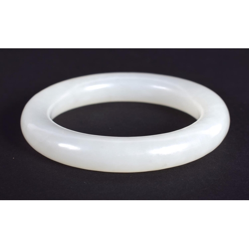 1252 - A CHINESE CARVED WHITE JADE CHILDS BANGLE 20th Century. 5.5 cm diameter.