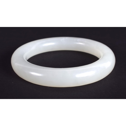 1252 - A CHINESE CARVED WHITE JADE CHILDS BANGLE 20th Century. 5.5 cm diameter.