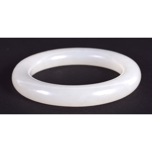 1265 - A CHINESE CARVED WHITE JADE CHILDS BANGLE 20th Century. 5.5 cm diameter.