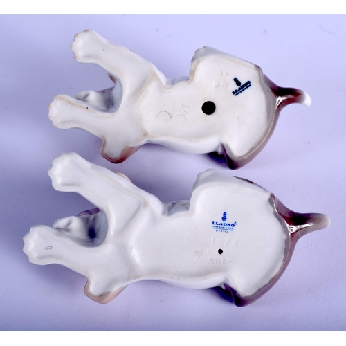 134 - A PAIR OF LLADRO PORCELAIN FIGURES OF SLEEPING HOUNDS. 15 cm wide.