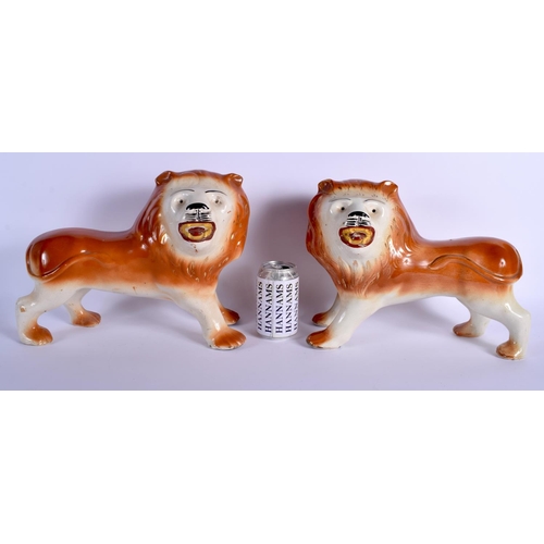 79 - A LARGE PAIR OF ANTIQUE CONTINENTAL POTTERY LIONS modelled roaming. 28 cm x 26 cm.