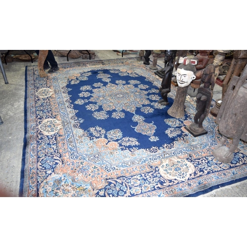 3133 - A Large Persian Blue ground Kirman Rug.  396cm x 304cm