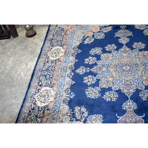 3133 - A Large Persian Blue ground Kirman Rug.  396cm x 304cm