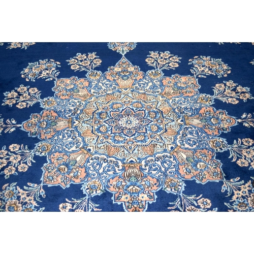 3133 - A Large Persian Blue ground Kirman Rug.  396cm x 304cm