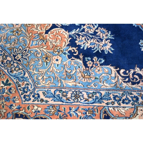 3133 - A Large Persian Blue ground Kirman Rug.  396cm x 304cm