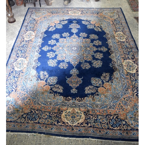 3133 - A Large Persian Blue ground Kirman Rug.  396cm x 304cm