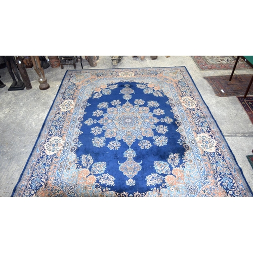 3133 - A Large Persian Blue ground Kirman Rug.  396cm x 304cm