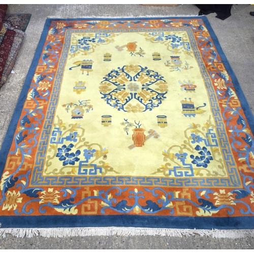 3134 - A Large Yellow ground rug decorated with auspicious symbols.  366cm x 274cm