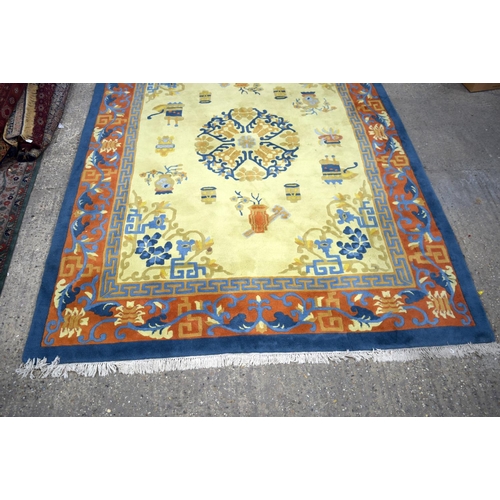 3134 - A Large Yellow ground rug decorated with auspicious symbols.  366cm x 274cm