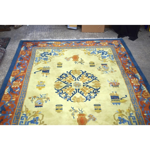 3134 - A Large Yellow ground rug decorated with auspicious symbols.  366cm x 274cm