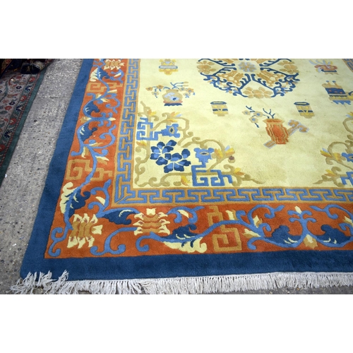 3134 - A Large Yellow ground rug decorated with auspicious symbols.  366cm x 274cm