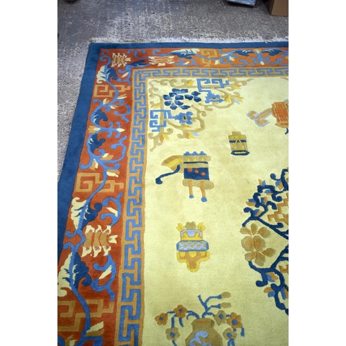 3134 - A Large Yellow ground rug decorated with auspicious symbols.  366cm x 274cm