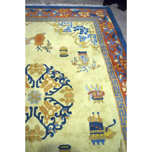 3134 - A Large Yellow ground rug decorated with auspicious symbols.  366cm x 274cm