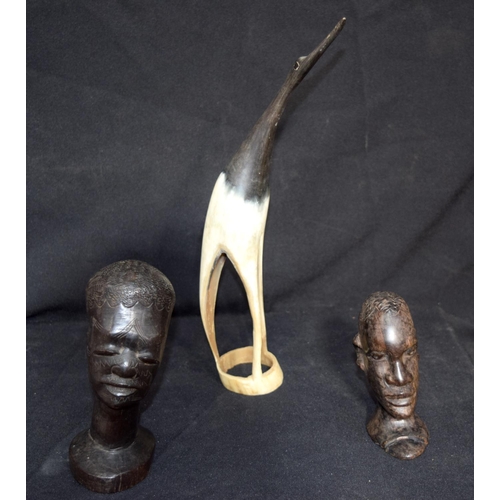 3236 - A scarified African Hardwood head together with another similar and a horn bird