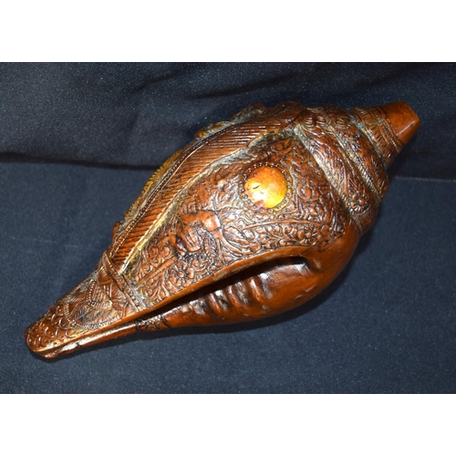 3243 - A Tibetan bronze snail shell decorated with figures.  24cm x 12 cm