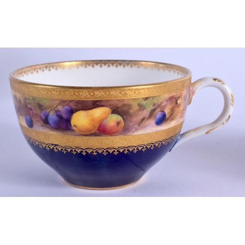 134 - A ROYAL WORCESTER TEACUP AND SAUCER painted with a band of fruit on a mossy bank above a blue and gi... 