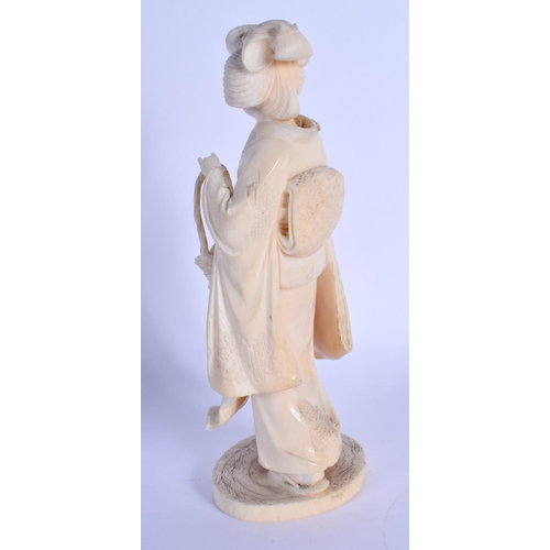 1560 - A 19TH CENTURY JAPANESE MEIJI PERIOD CARVED IVORY OKIMONO modelled as a standing geisha. 17 cm high.