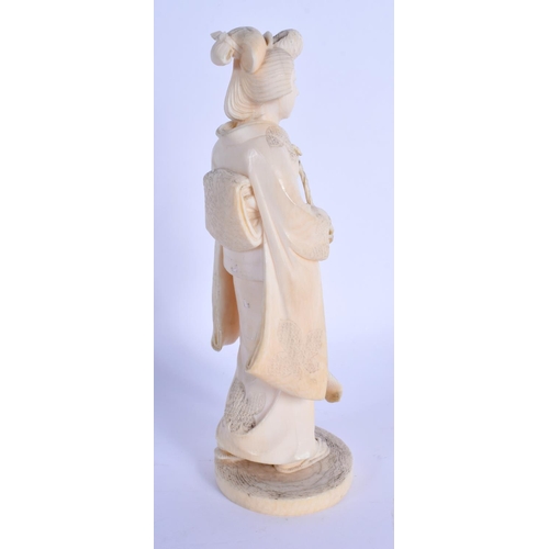 1560 - A 19TH CENTURY JAPANESE MEIJI PERIOD CARVED IVORY OKIMONO modelled as a standing geisha. 17 cm high.