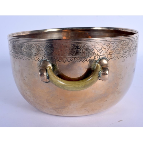 1562 - A 19TH CENTURY INDO TIBETAN TWIN HANDLED POLISHED BRASS CENSER with carved rhinoceros horn handles, ... 