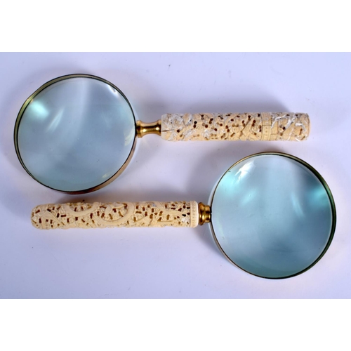 1591 - A PAIR OF 19TH CENTURY CHINESE CARVED CANTON IVORY MAGNIFYING GLASSES decorated with dragons and fol... 