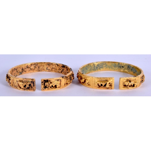 1682 - AN UNUSUAL PAIR OF 18TH/19TH CENTURY CHINESE GILT BRONZE BANGLES Qing, decorated with figures and la... 