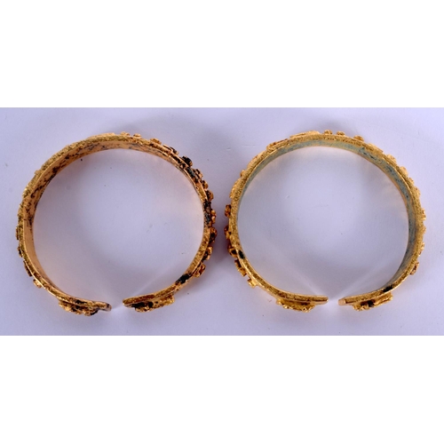 1682 - AN UNUSUAL PAIR OF 18TH/19TH CENTURY CHINESE GILT BRONZE BANGLES Qing, decorated with figures and la... 